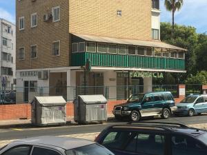 een gebouw met auto's geparkeerd aan de kant van een straat bij Apartamento Alberche in Sevilla