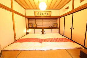 - une chambre avec un grand lit dans l'établissement Fuji Sakura House, à Fujikawaguchiko