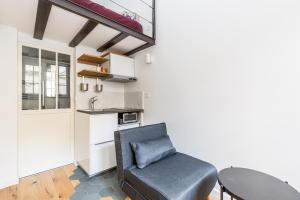 uma sala de estar com uma cadeira e uma mesa em Le Loft du Marais em Paris