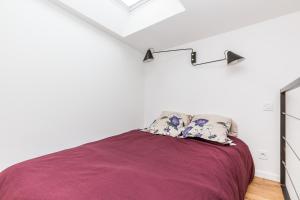 a bedroom with a bed with a purple blanket at Le Loft du Marais in Paris