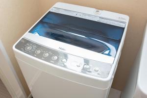 a white washing machine with its door open at Tourisakuraann 2goukann in Kyoto