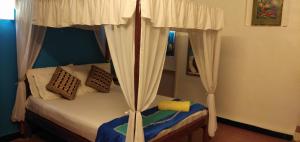1 dormitorio con 1 cama con dosel en Serene Waters Homestay Goa, en Panaji
