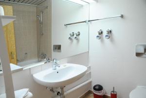 a white bathroom with a sink and a shower at SEEGER Living Classic East in Karlsruhe