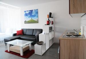 a living room with a couch and a kitchen at SEEGER Living Classic East in Karlsruhe