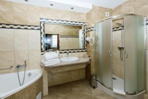 a bathroom with a tub and a sink and a shower at Dziki Potok Konferencje Grill & Prestige SPA in Karpacz