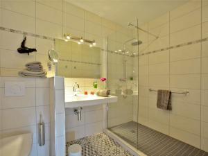 y baño con ducha, lavabo y espejo. en Hôtel Le Quatorze, en Figeac