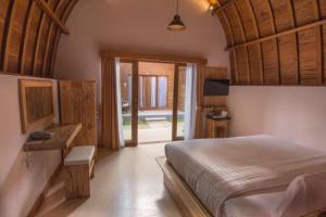 a bedroom with a large bed with a wooden ceiling at Uma Mani Villa Bali in Jimbaran