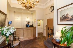 a man standing at a reception desk in a lobby at The Castleton Hotel in London