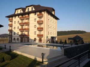 a large building with a pool in front of it at Sunset Zlatibor Hills in Zlatibor