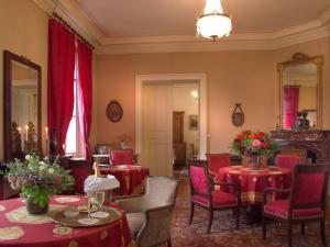 a dining room with red tables and chairs and a mirror at Château des Tertres in Onzain