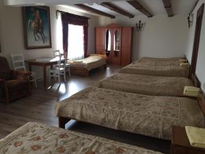 コジェニツェにあるZajazd Rycerskiのベッドルーム1室(ベッド2台、テーブル、椅子付)