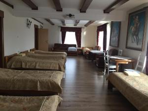 a room with several beds and a living room at Zajazd Rycerski in Kozienice