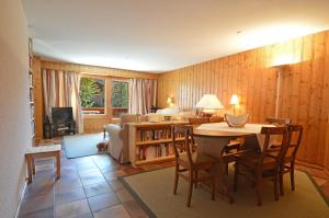 a living room with a table and chairs and a couch at Centre Etoile 130 in Verbier