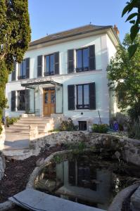 una casa con un estanque delante de ella en Maison d'hôtes LES RAINETTES, en Breuillet