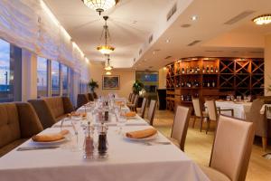 a dining room with a long table with white table cloth at Arena Di Serdica Hotel in Sofia