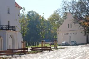a building with benches and a building with a sign that reads unity prayer at Olivův Pivovar in Dolní Břežany