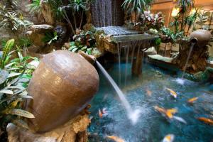 a pond with a water fountain in a garden at Deja Vu Hotel in Taipei