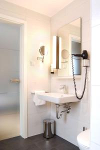 a bathroom with a sink and a mirror at SEEGER Living Premium West in Karlsruhe