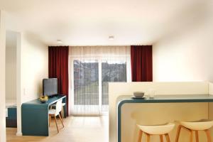 Habitación con cocina con mesa y sillas. en SEEGER Living Premium West en Karlsruhe