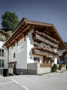 un edificio con un balcón con flores. en Apart Garni Enzian, en Sölden