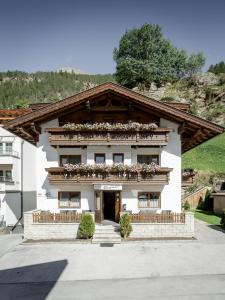 un edificio blanco con flores en la parte delantera en Apart Garni Enzian, en Sölden