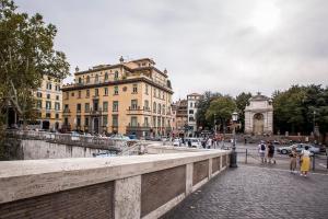 a group of people walking on a bridge over a river at Trastevere Royal Suite Trilussa in Rome