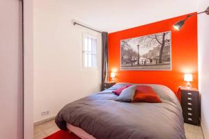 エクス・アン・プロヴァンスにあるL'Entrecasteauxのオレンジ色の壁のベッドルーム1室、ベッド1台が備わります。