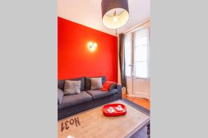a living room with a couch and a red wall at L'Entrecasteaux in Aix-en-Provence +5 photos