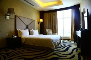 a hotel room with a bed and a large window at Sanam Hotel Suites - Riyadh in Riyadh +21 photos