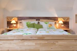 ザンクト・メルゲンにあるFerienwohnung Meierhofのベッドルーム1室(大型木製ベッド1台、ランプ2つ付)