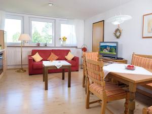 uma sala de estar com um sofá vermelho e uma mesa em Ferienwohnung Meierhof em Sankt Märgen