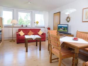 ザンクト・メルゲンにあるFerienwohnung Meierhofのリビングルーム(赤いソファ、テーブル付)