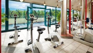 un gimnasio con máquinas cardiovasculares y vistas a la piscina en Spa Resort Libverda - Hotel Nový Dům, en Lázně Libverda