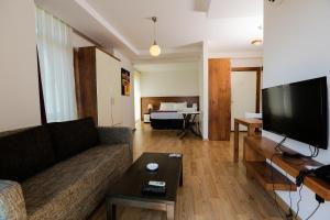 a living room with a couch and a flat screen tv at Upart Home in Mersin