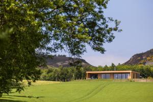 una casa en una colina con un campo verde en The Hideaway Experience en Dundee