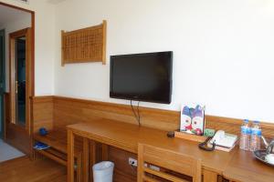 a wooden desk with a television on top of it at Ginkgo Hotel in Lugu Lake
