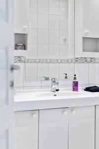 a white bathroom with a sink and a mirror at Apartment Bergen Central in Bergen