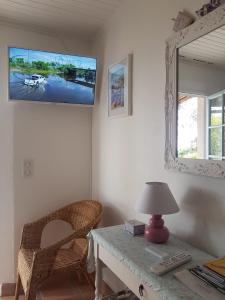 Habitación con mesa, lámpara y espejo. en villa des oliviers, en Le Tignet