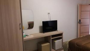 a room with a television on a table in a room at Roseate Bangkok Hotel in Bangkok