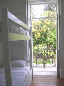 a bedroom with a bunk bed and a large window at WW Hostel & Suites in Coimbra