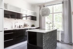 uma cozinha com um balcão preto e branco e uma janela em Central Alexandra em Tampere