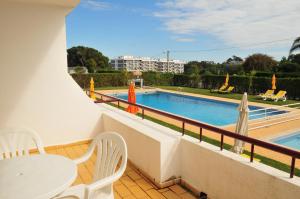 a balcony with a swimming pool and a table and chairs at Solgarve in Quarteira