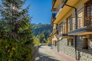 a street with a car parked on the side of a building at Rent like home - Krzeptówki in Zakopane