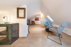 einen Flur mit Stühlen, einem Tisch und einem Spiegel in der Unterkunft Design Apartments - "Potsdam City" 18 in Potsdam