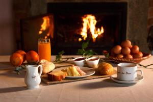 una mesa con comida y bebida y una chimenea en Lugar dos Devas, en Covelo