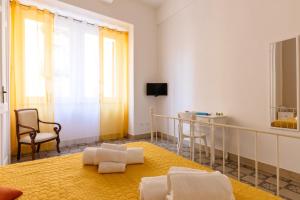 una camera con tappeto giallo, tavolo e sedia di Il Tarì Apartment a Palermo
