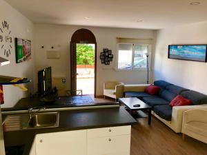 un salon avec un canapé bleu et une cuisine dans l'établissement Tarifa Surf Center Apartment, à Tarifa