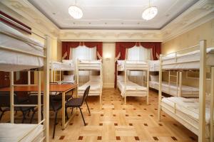 een kamer met een stapelbed en een tafel en stoelen bij Hostel Suputnyk in Lviv