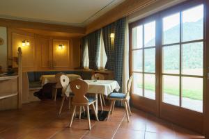 a dining room with a table and chairs and a window at Agritur Cornasest in Breguzzo