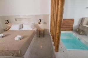 a bedroom with a bed and a swimming pool at Hector Cave House in Oia
